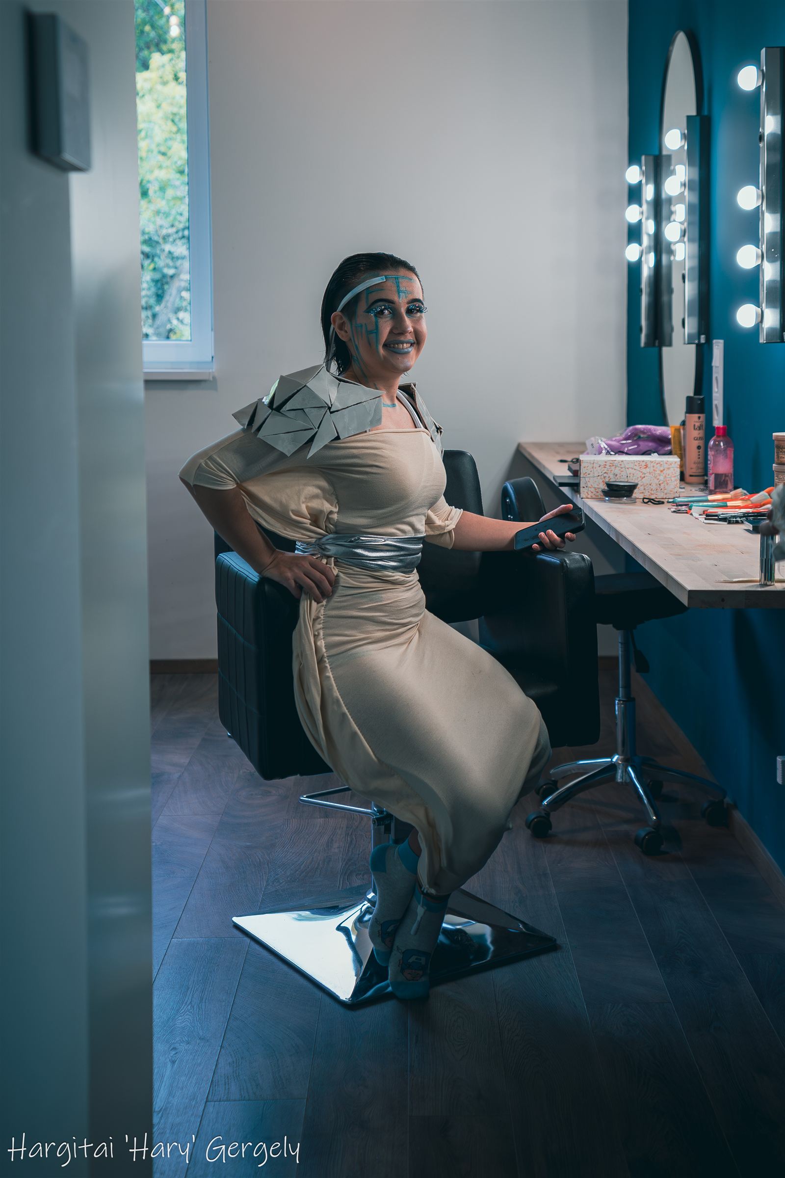 Lume actress in full costume with sculpted shoulder piece in the make-up room