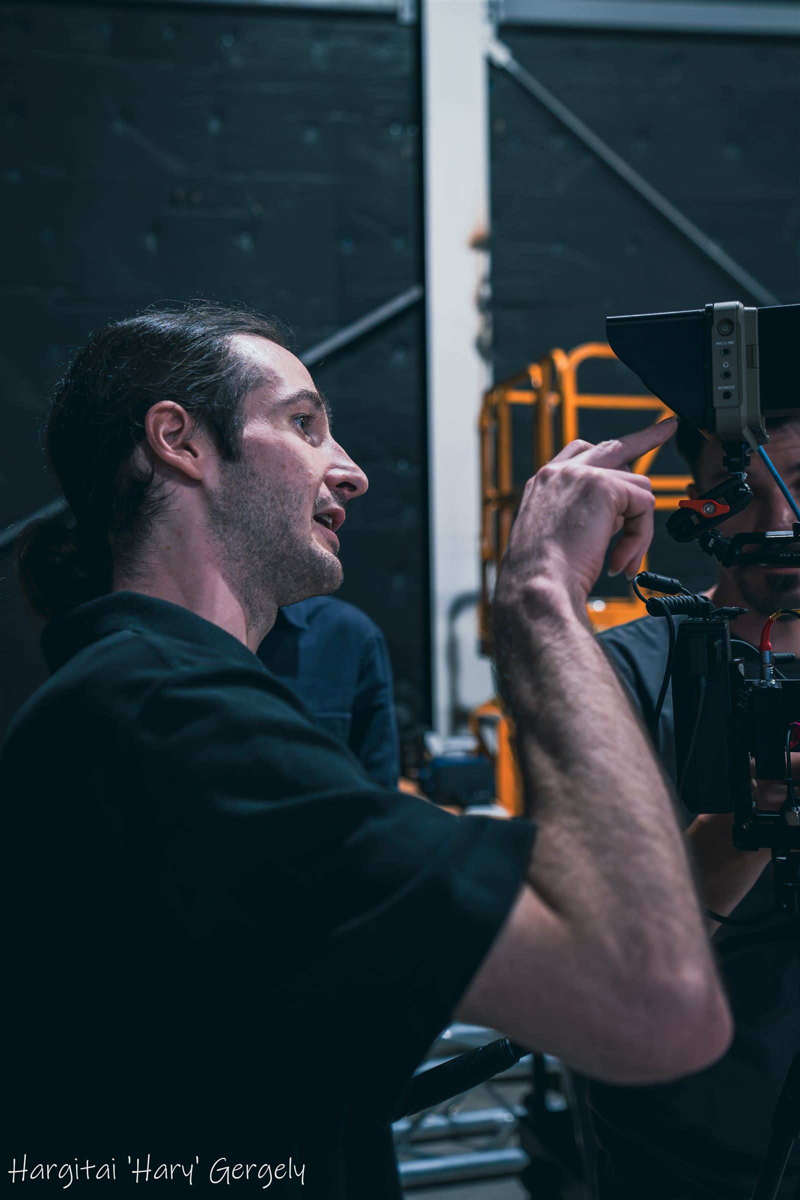 Camera crew member directing beside the rig